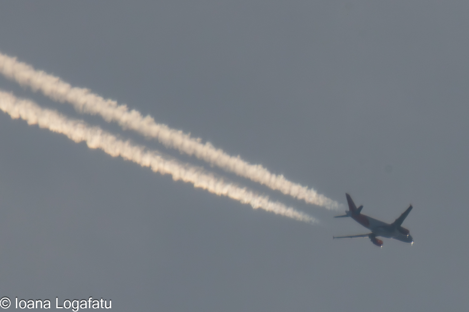 Jet gliding through clouds, leaving trails